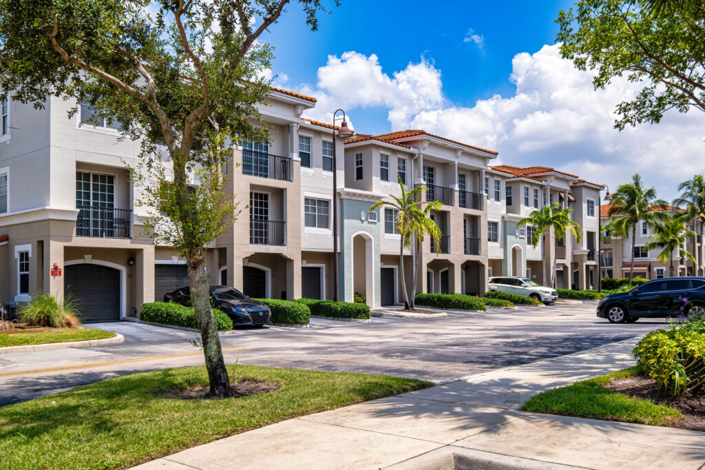 Exterior view of buildings with garages on the first level and additional parking spots